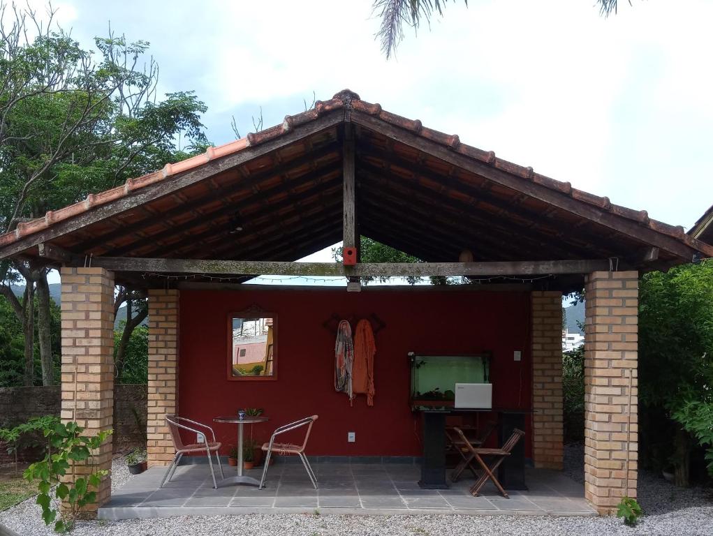 Vila Verde Suites في فلوريانوبوليس: منزل احمر مع كراسي وطاولة