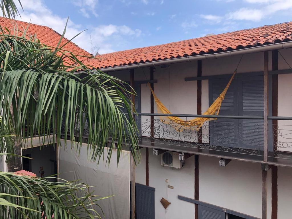 a balcony of a house with a hammock on it at Palma Hostel in São Luís