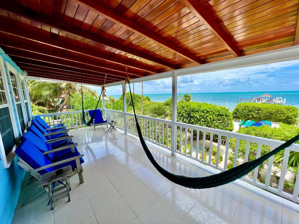 a porch with a hammock and chairs on a balcony at Laura's Lookout in Caye Caulker