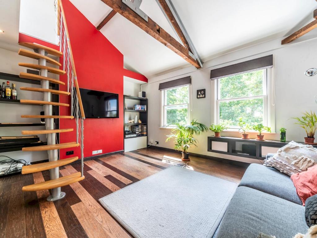 sala de estar con pared roja en Pass the Keys Stylish Apartment In The Heart Of Richmond, en Richmond