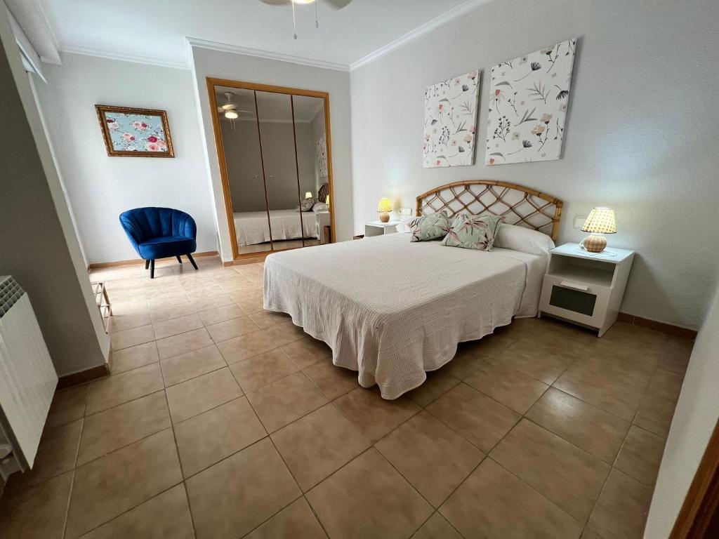 1 dormitorio con 1 cama y 1 silla azul en El Recreo, private Pool & Bbq, en Godelleta