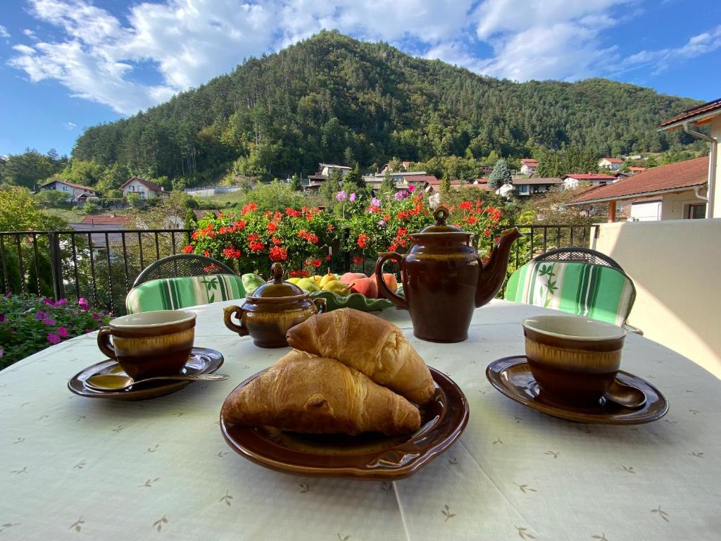 a table with a plate of bread and tea pots and cups at Apartment BRIONI in Laško