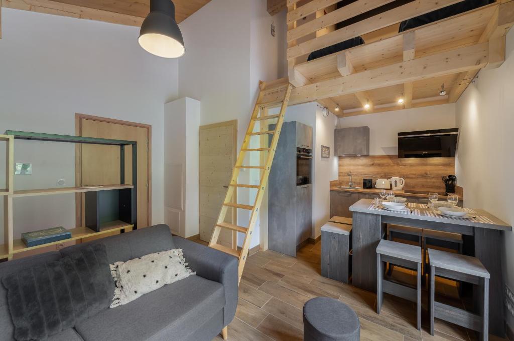 een woonkamer met een bank en een keuken met een ladder bij Perle de savoie - Apt C706 - BO Immobilier in Châtel
