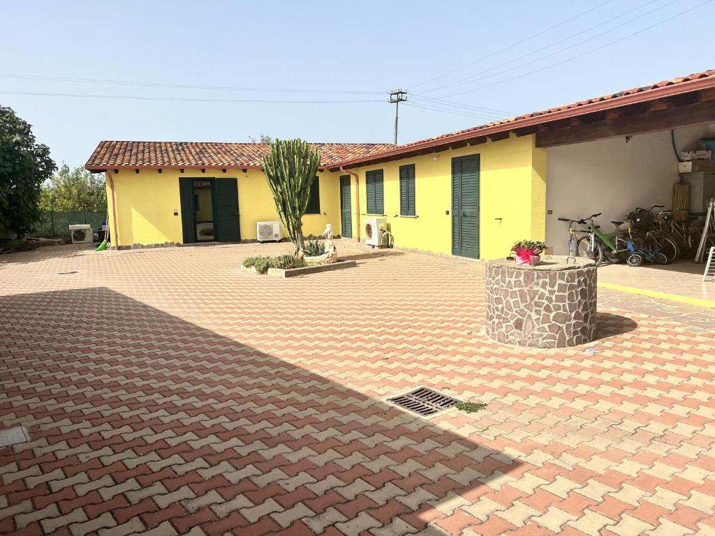 una casa amarilla con una entrada de ladrillo delante de ella en Residence Sulcis 2, en Masainas
