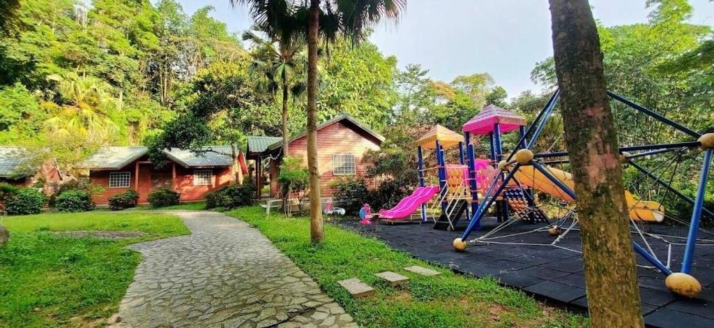 um quintal com um parque infantil e uma casa em UT Chaung Homestay 