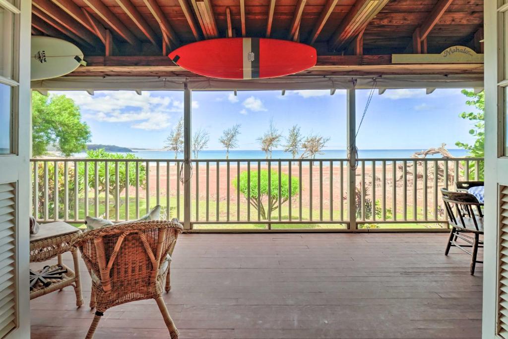 a large screened porch with a red surfboard at Tropical Paniolo Hale Townhome, Walk to Beach in Maunaloa