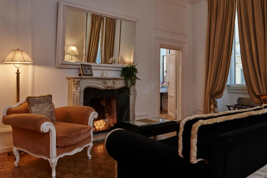 a living room with a chair and a fireplace at Casa Howard Firenze - Residenza d'Epoca in Florence
