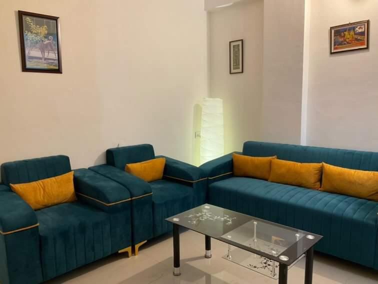 - un salon avec un canapé bleu et une table dans l'établissement R.H.S VILLA, à Varanasi