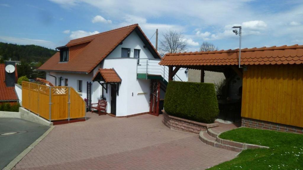 een wit huis met een bruin dak en een oprit bij Ferienwohnung Frenzel in Kurort Gohrisch
