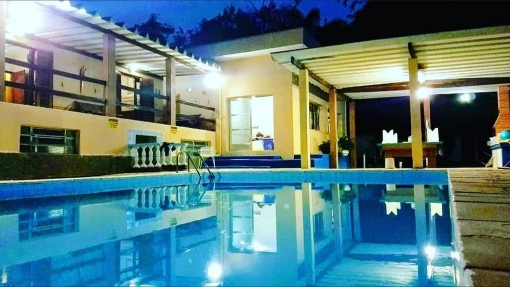 una piscina frente a una casa por la noche en Chácara em Guararema Brasil en Guararema