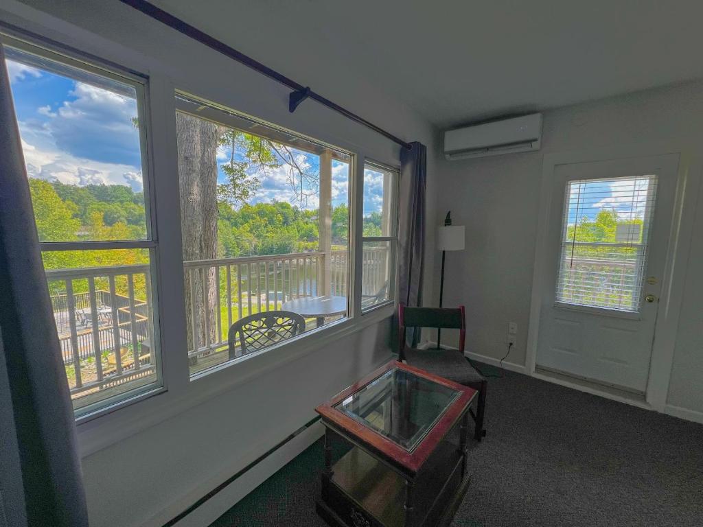 a room with windows and a chair and a balcony at Inn at the Falls in Bracebridge