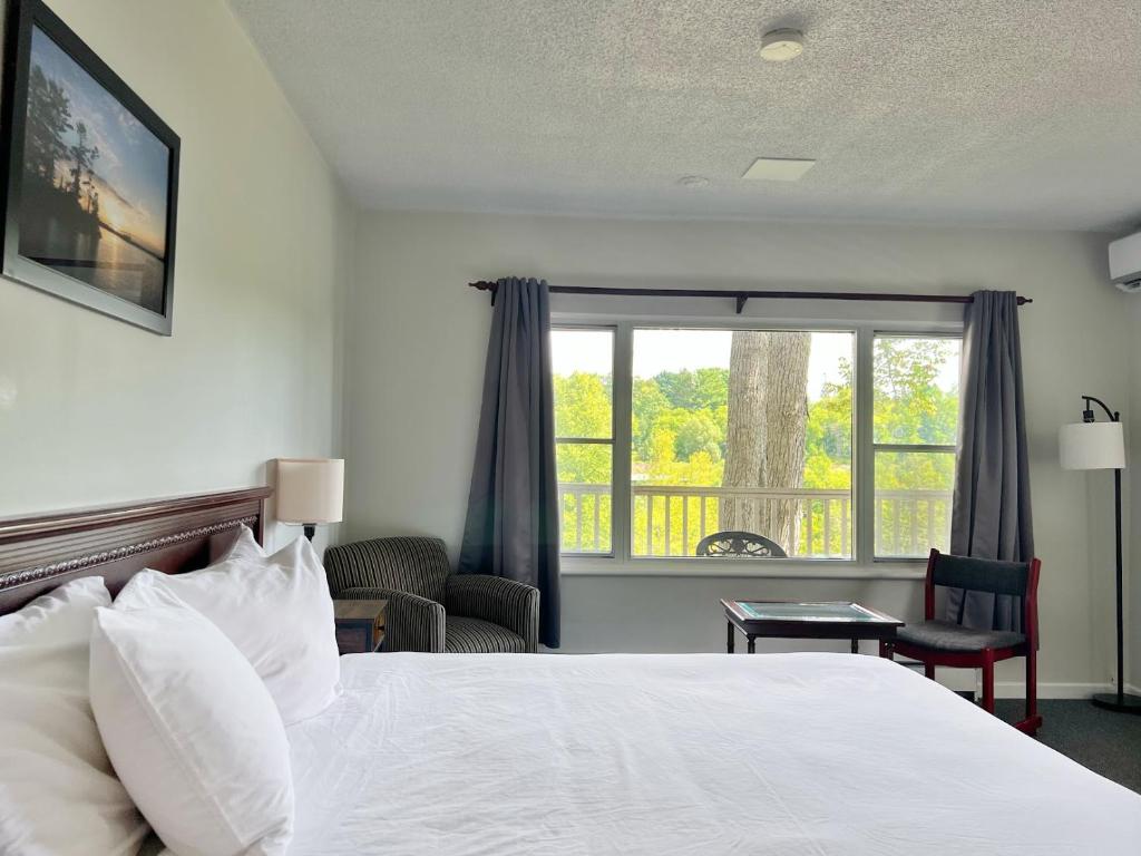 a hotel room with a bed and a window at Inn at the Falls in Bracebridge
