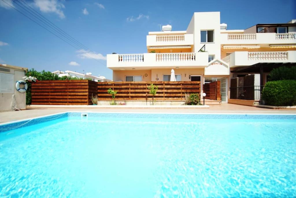 uma piscina em frente a uma casa em Central Pool-Side 2 Bedroom Apartment in Paphos em Pafos