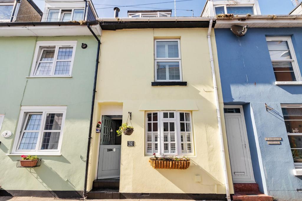 Casa blanca y azul con puertas y ventanas blancas en Hope Cottage, Brixham, en Brixham