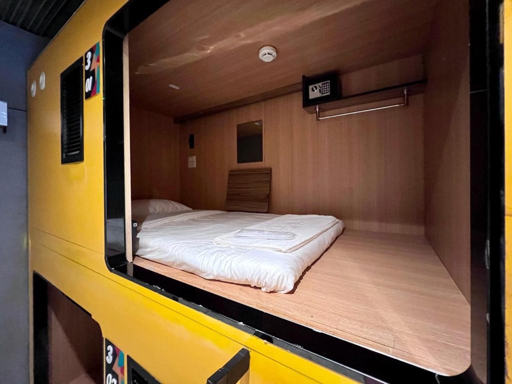 una cama en la parte trasera de un autobús amarillo en Icon Hotel Hatyai en Hat Yai
