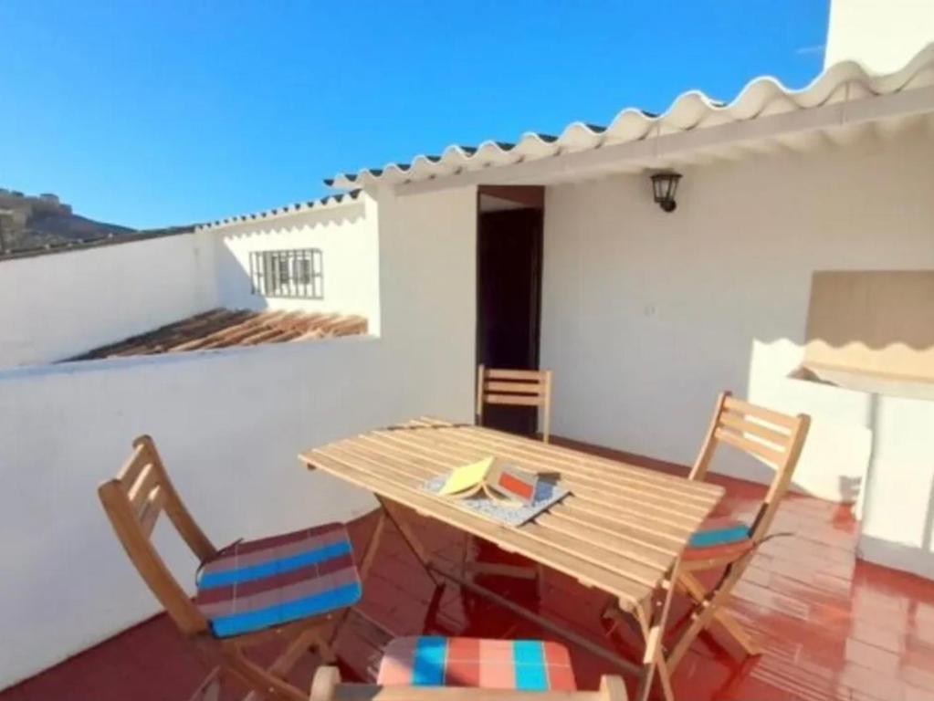 een houten tafel en stoelen op een patio bij Sunset Casita in Alora