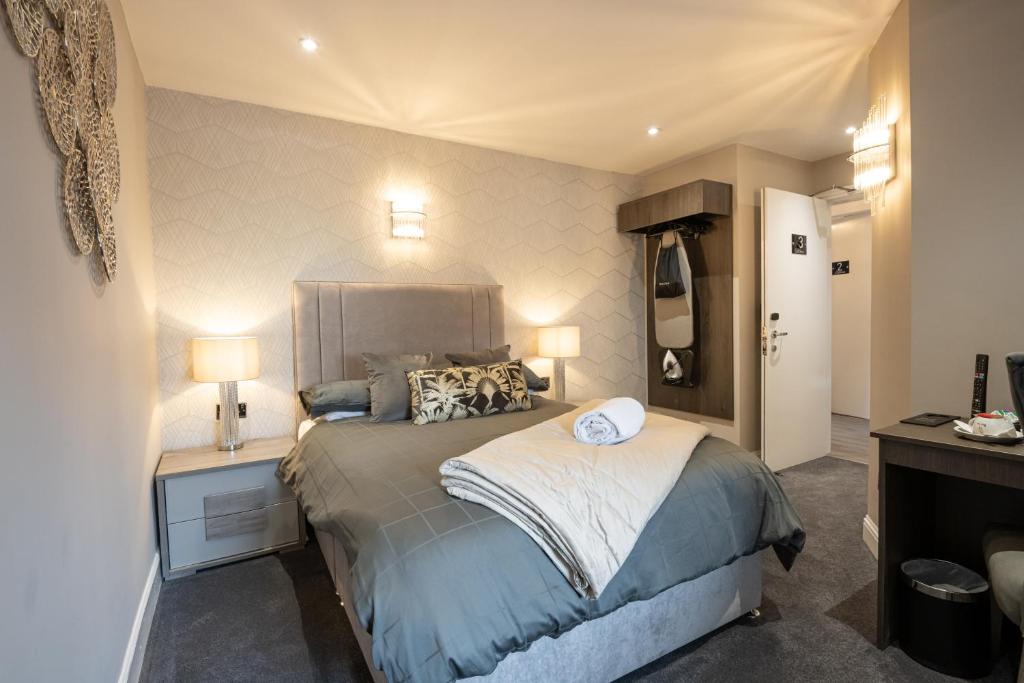 a bedroom with a bed and a nightstand with two lamps at The Fort Hotel in Dundee