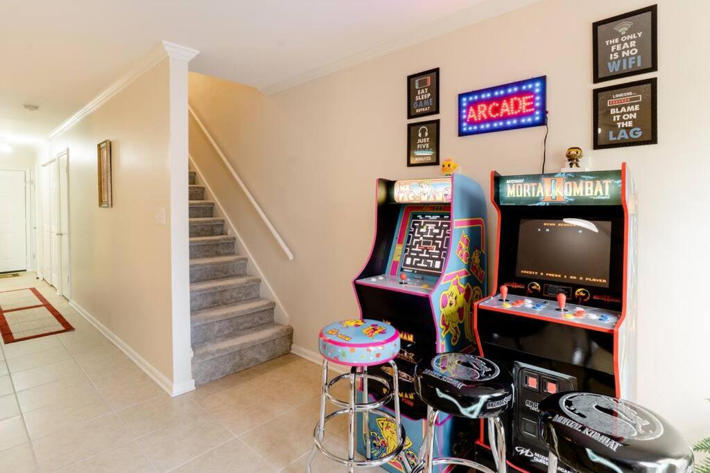 a room with two video game machines and stools at Cozy Family Retreat with Arcade, Grill, Waffle Bar & Firepit in Norcross