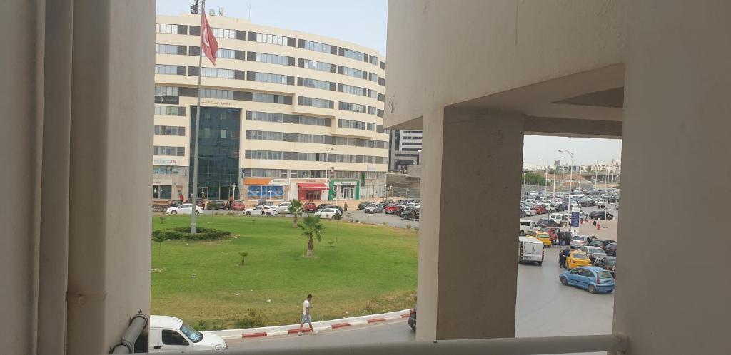- une vue sur un parking avec un grand bâtiment dans l'établissement Le Palace Clinique Jasmin Carthgene Pasteur, à Tunis