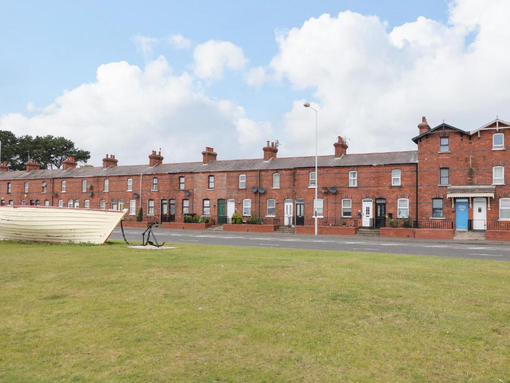 a large brick building with a grass field in front of it at Lough Mill House in Newtownabbey