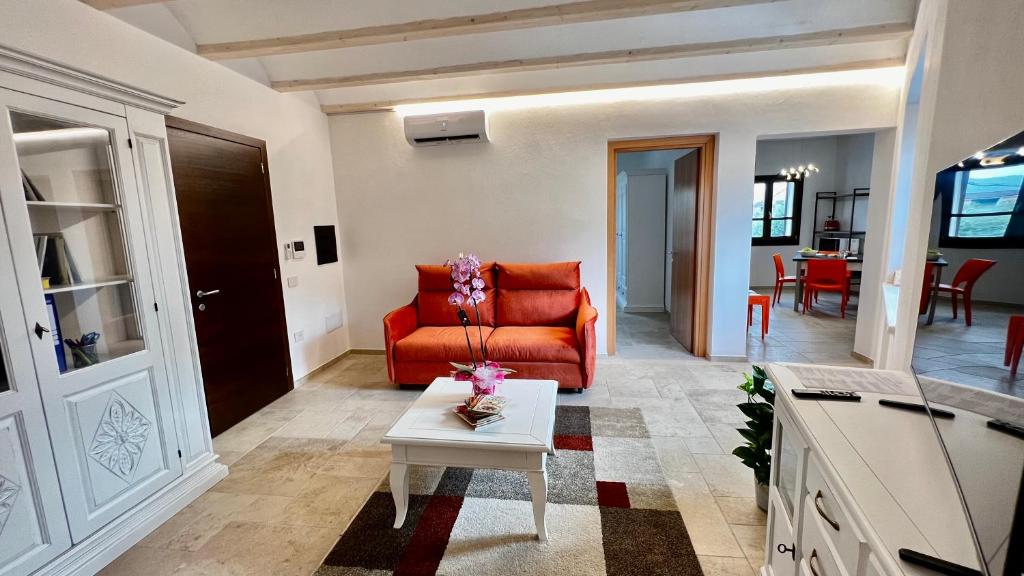 a living room with an orange couch and a table at casa di natalie in Girasole