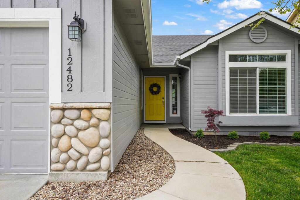 dom z żółtymi drzwiami i podjazdem w obiekcie Remodeled, Charming Retreat on the City's Doorstep w mieście Boise
