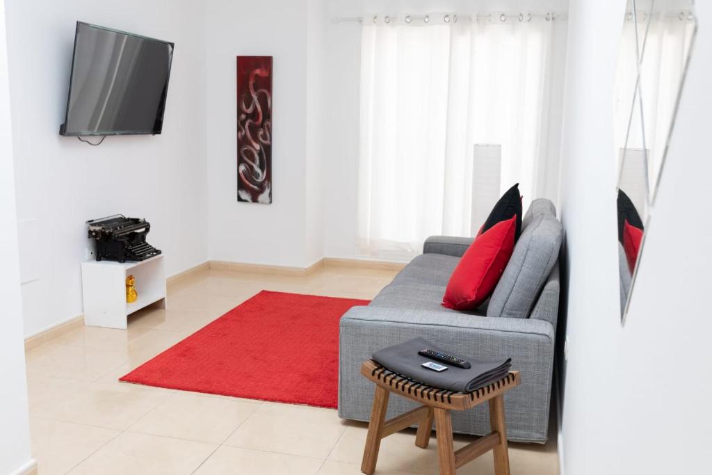 un soggiorno con divano grigio e tappeto rosso di White House ad Arrecife