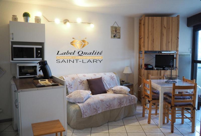 a living room with a kitchen and a table with a couch at Coquet appartement 5 places labélisé tout équipé in Saint-Lary-Soulan