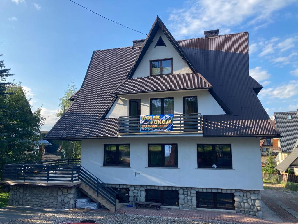 a large white building with a black roof at Apartament Miś in Zakopane