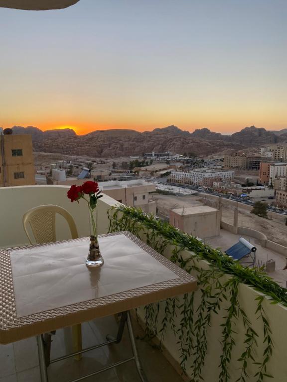 a vase with a flower on a table on a balcony at Hustle's look in Wadi Musa