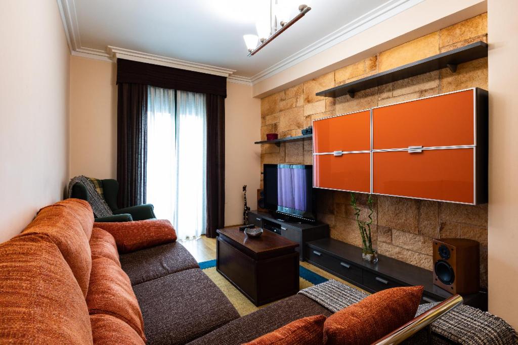 a living room with a couch and a television at piso vacacional en la playa de Rodeira in Cangas de Morrazo