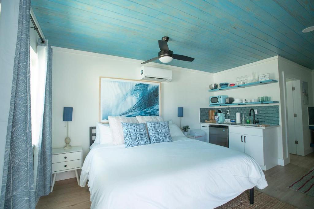 a bedroom with a white bed and a blue ceiling at Casa Limonada Boutique Motel in Sarasota