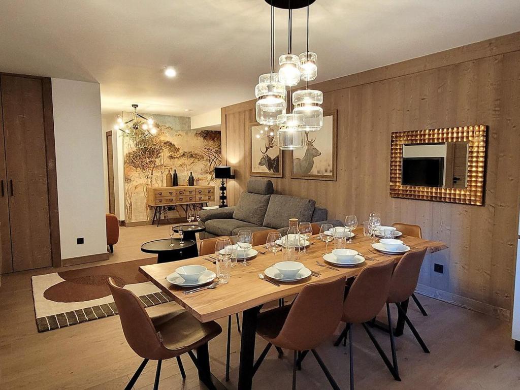 a dining room and living room with a table and chairs at Appartement central tout confort avec grande terrasse, WIFI, PARKING, 8 personnes - FR-1-598-99 in Les Gets