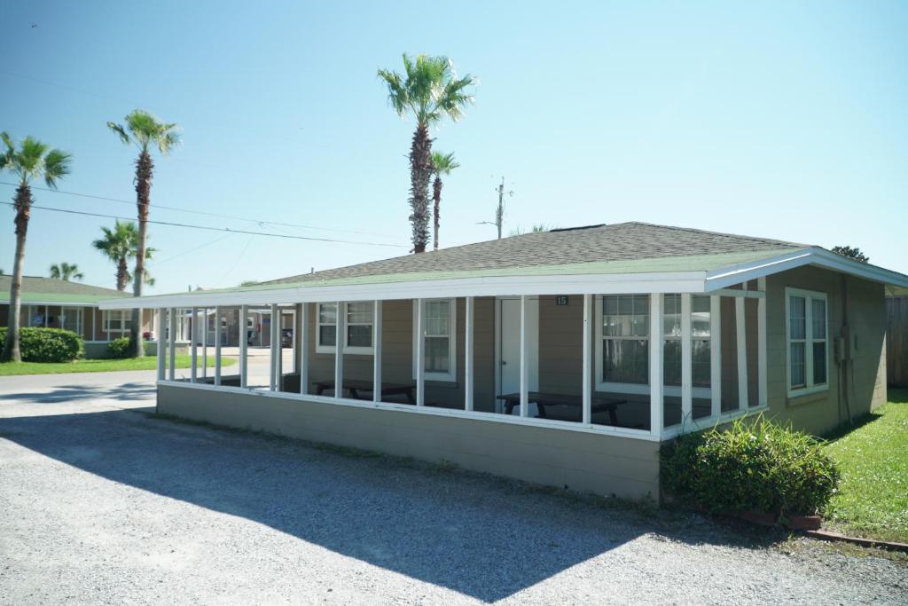 a screened in porch of a house with palm trees at Cottages Christian Retreat in Panama City Beach