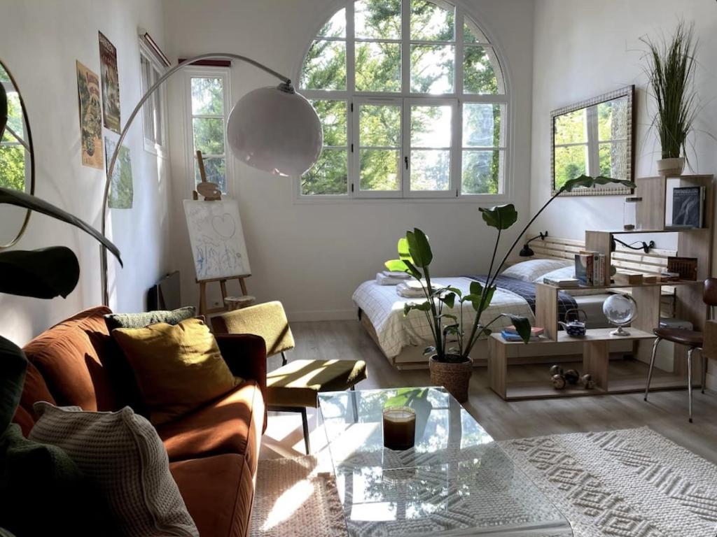uma sala de estar com um sofá e uma cama em Karma Loft Barbizon - 40m2 em Barbizon