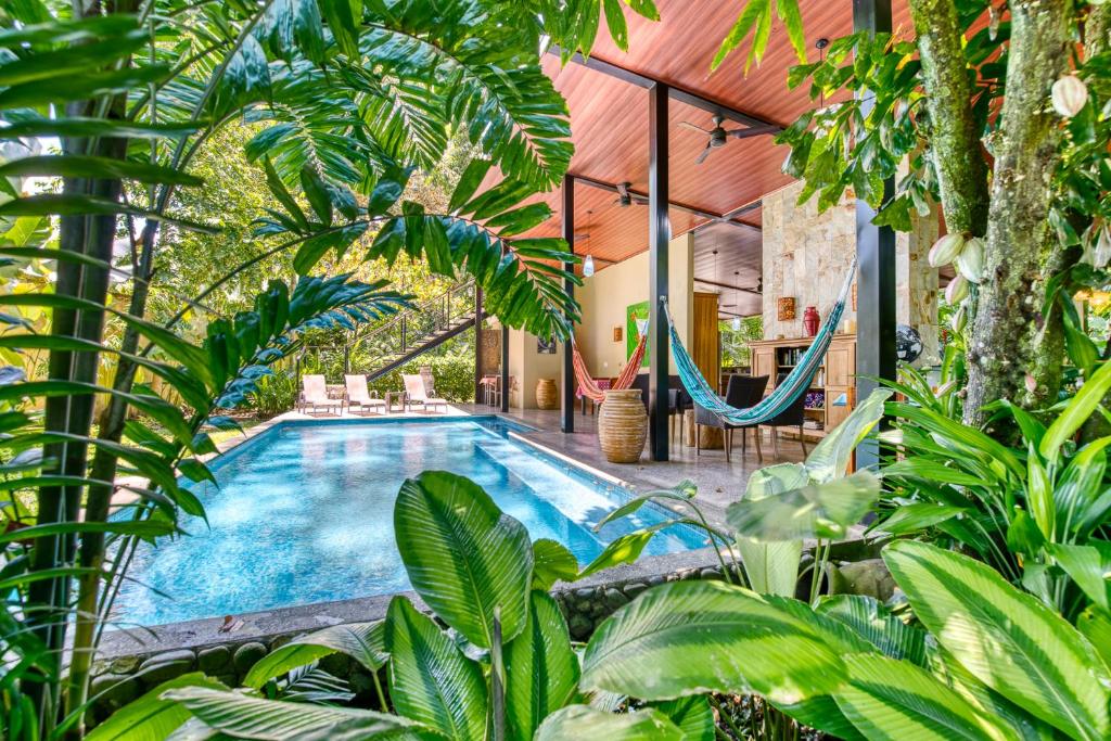 - une piscine intérieure dans une maison ornée d'arbres et de plantes dans l'établissement Villas Piña - Adults only, à Puerto Viejo