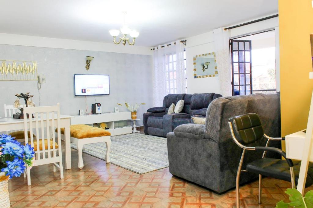 a living room with a couch and a chair at The Gem - Kiambu road 1 bedroom in Kiambu