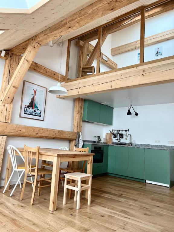 a kitchen with green cabinets and a wooden table at Triplex In The Heart Of Chamonix in Chamonix-Mont-Blanc