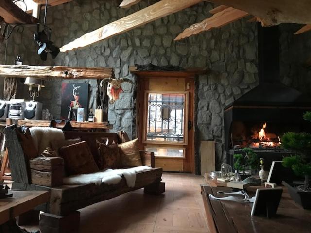 ein Wohnzimmer mit einem Sofa und einem Kamin in der Unterkunft BORDEMAIPO LODGE in San José de Maipo