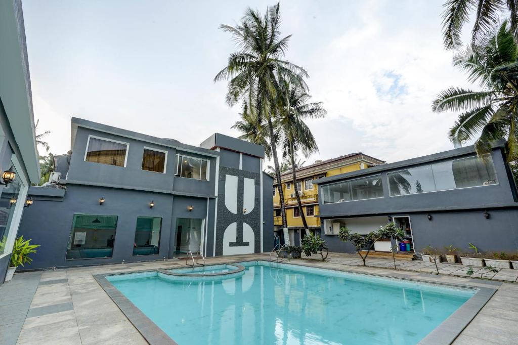 an exterior view of a house with a swimming pool at Hotel Plaza Inn by Rio in Calangute
