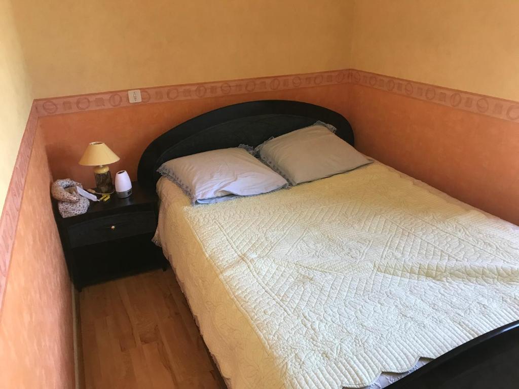 1 dormitorio con 1 cama grande y cabecero de madera en Appartement silencieux avec une belle vue . en Morez