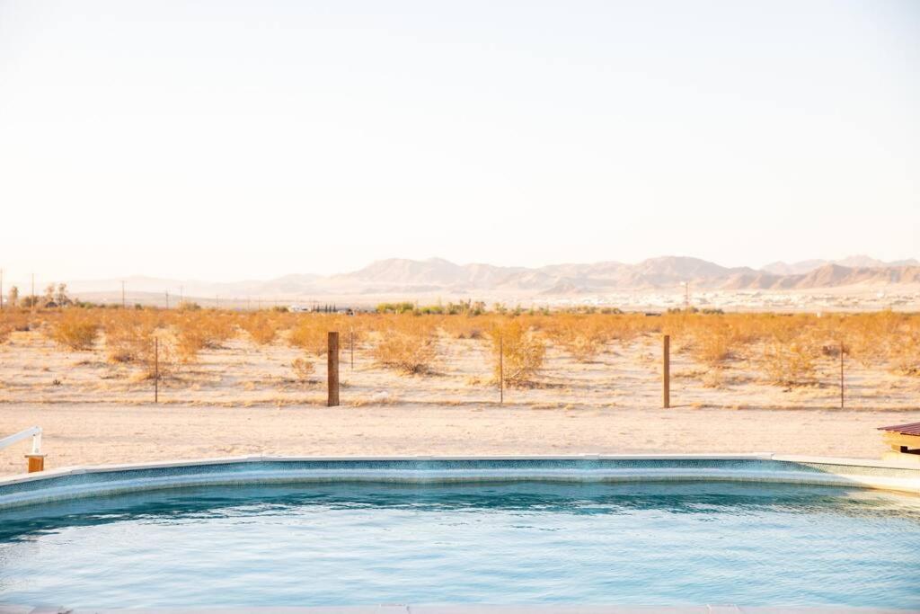 a swimming pool in the middle of a desert at Sun Runner - Serene desert home w/pool & hot tub in Twentynine Palms