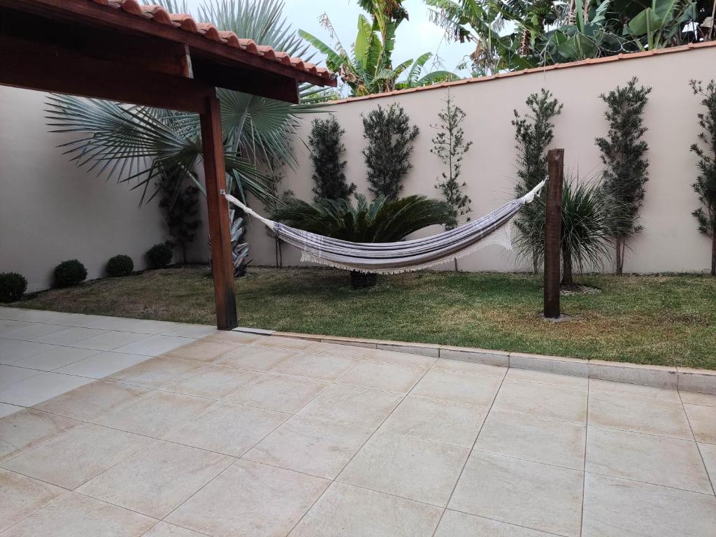 a hammock in a yard next to a house at Casa temporada AURORA in São João Batista do Glória