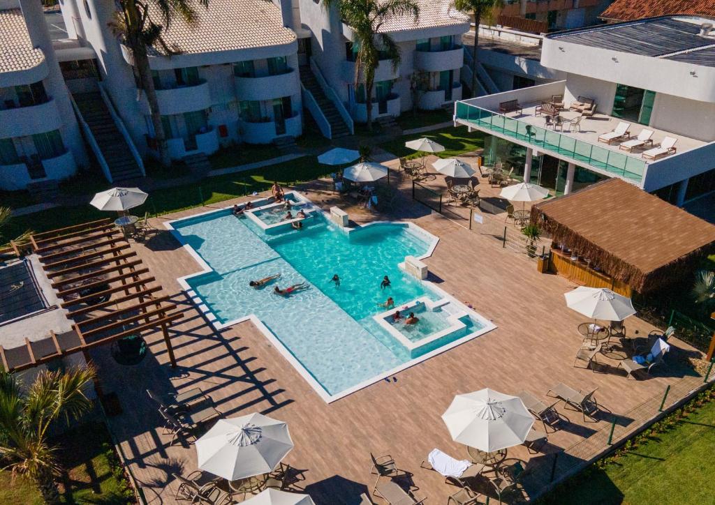 an overhead view of a swimming pool with umbrellas at Makkai Resort Bombinhas in Bombinhas