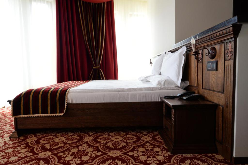 a bedroom with a bed and a large window at Castel Transilvania in Baia Mare