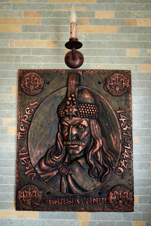 a statue of a man with a candle on a wall at Castel Transilvania in Baia Mare