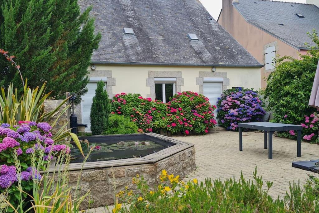 um jardim com flores em frente a uma casa em Grande Maison dans le Bourg de Nevez + jardin em Névez