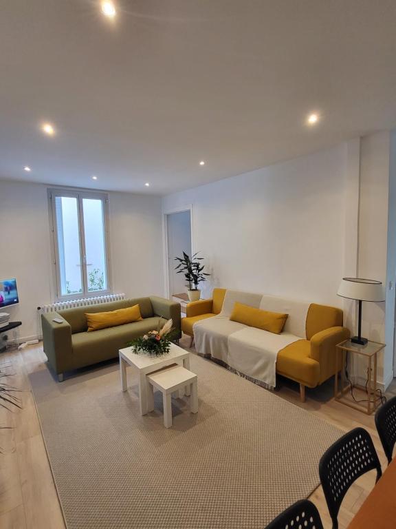 uma sala de estar com um sofá e uma mesa em Maison COSY à 4km BERCY ARENA 15mn PARIS gare 800m em Vitry-sur-Seine