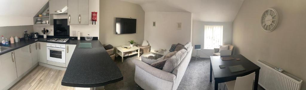 a kitchen and living room with a couch and a table at The Cosy Apartment Sherburn in Elmet in Sherburn in Elmet