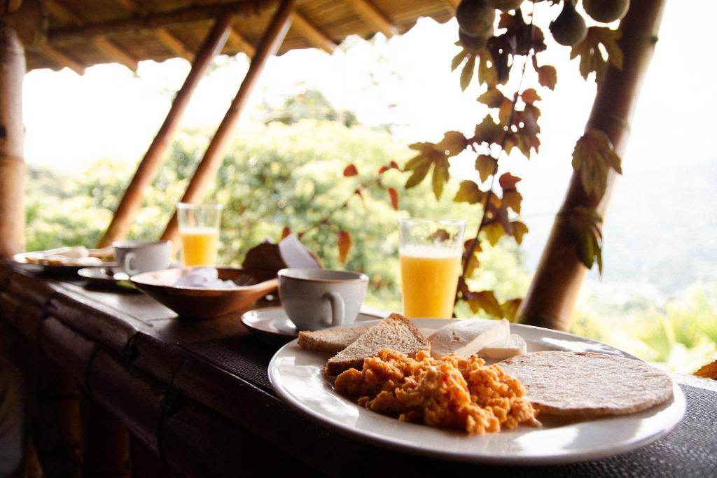 a table with a plate of food with toast and bread at Ecohotel Tierra de Agua in Cocorná